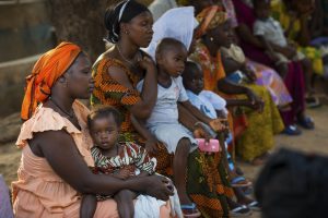 Portrait of a young mother and her baby daughter during a community meeting, at the Bissaque neighborhood in the city of Bissau